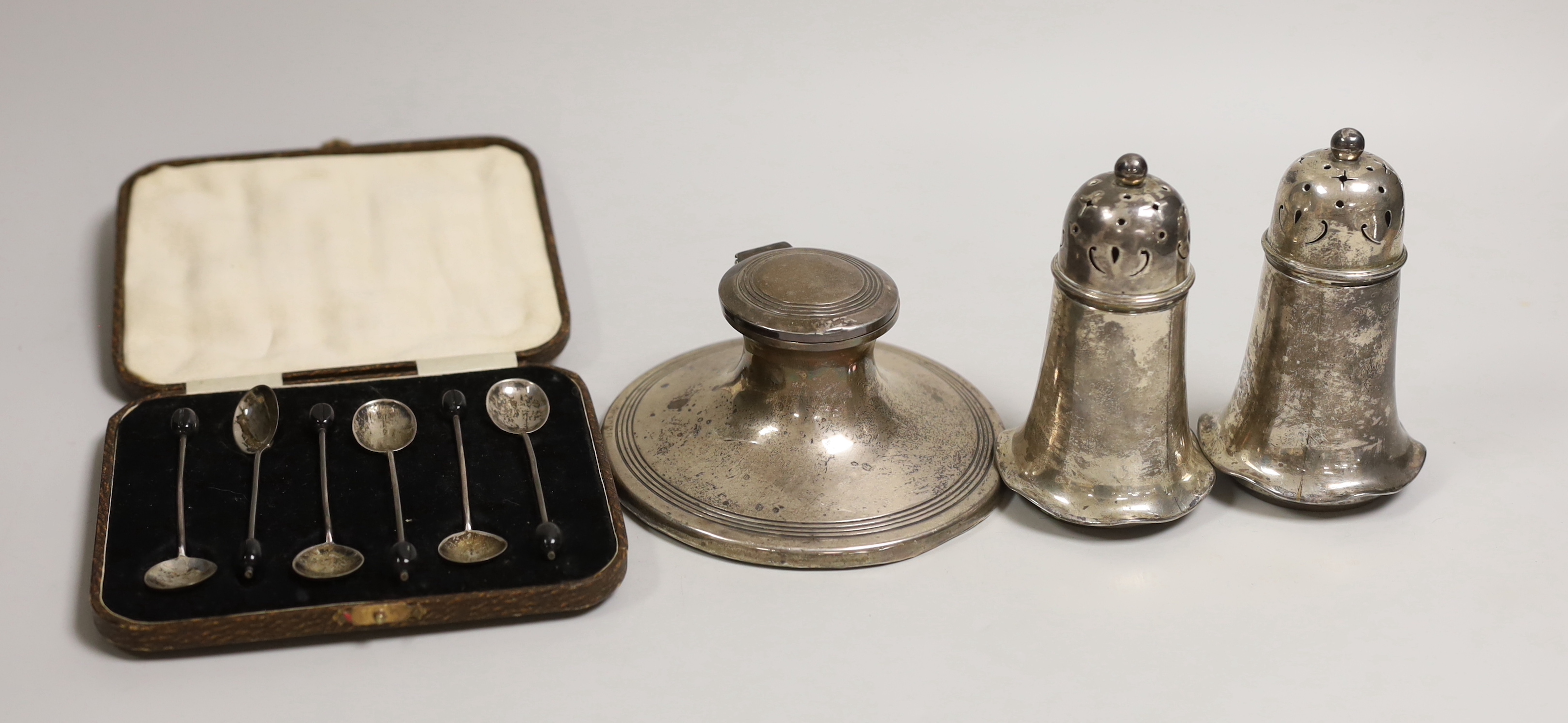 A pair of Edwardian silver sugar casters, Sheffield, 1907, 11.2cm, a silver mounted capstan inkwell and cased set of six silver bean end coffee spoons.